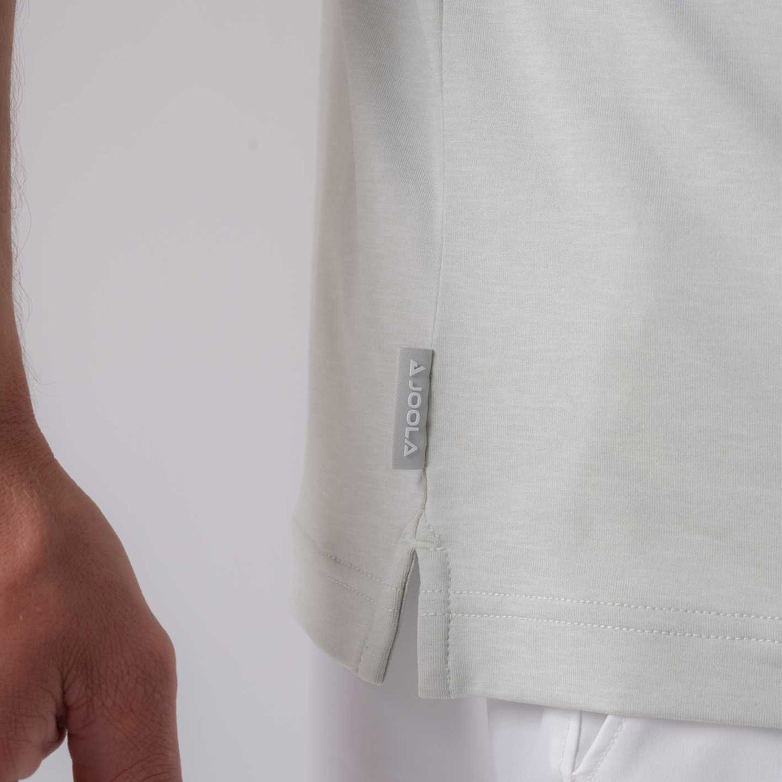 Close up image of a raised JOOLA tag on the side of a men's club polo, gray heather.