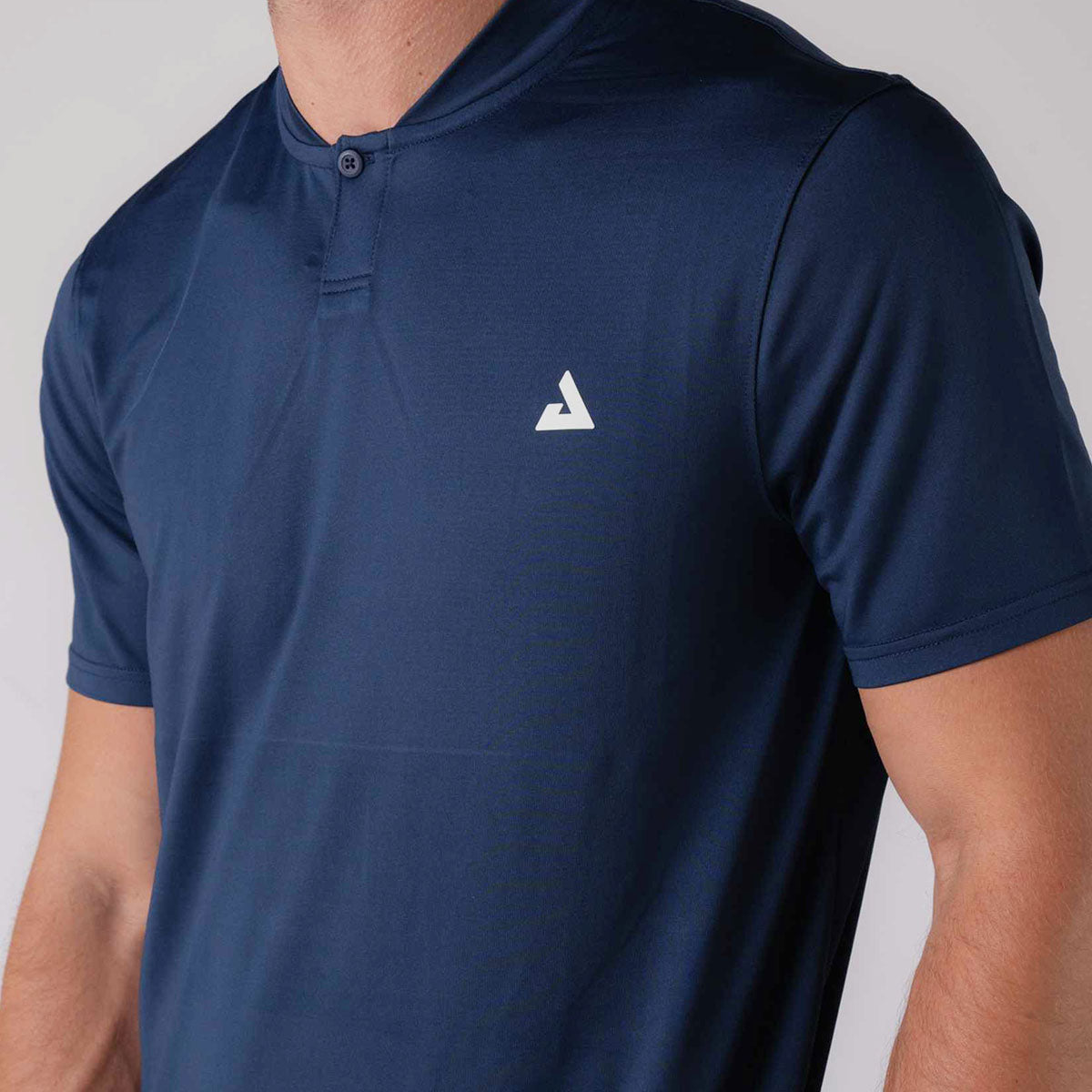 Close up image showing the JOOLA trinity logo on the JOOLA men's court polo, navy.