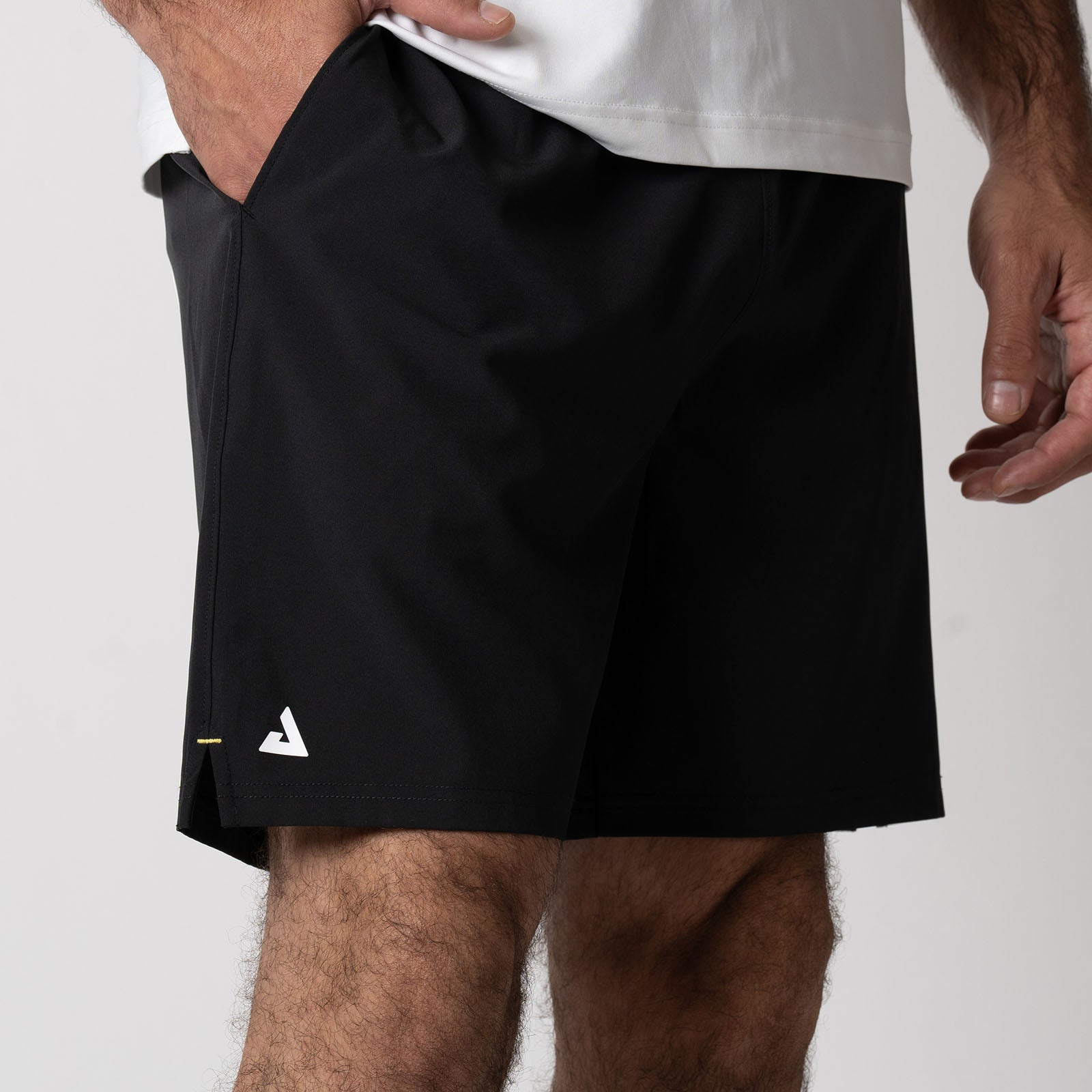 Close up showing the detailed JOOLA Trinity logo on the leg of a pair of JOOLA Men's Woven Shorts, 7 inch inseam, black.