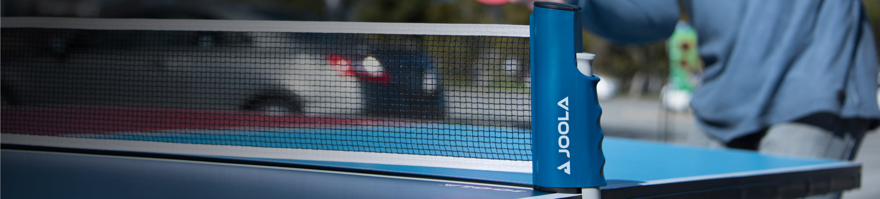 Horizontal header image of an outdoor JOOLA table tennis table.