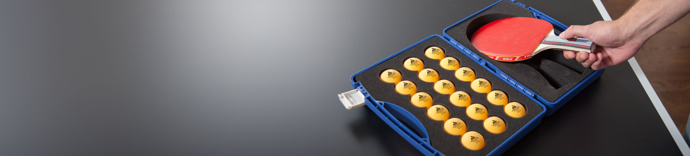 Horizontal banner image of a JOOLA Table Tennis Racket with table tennis ball holder.