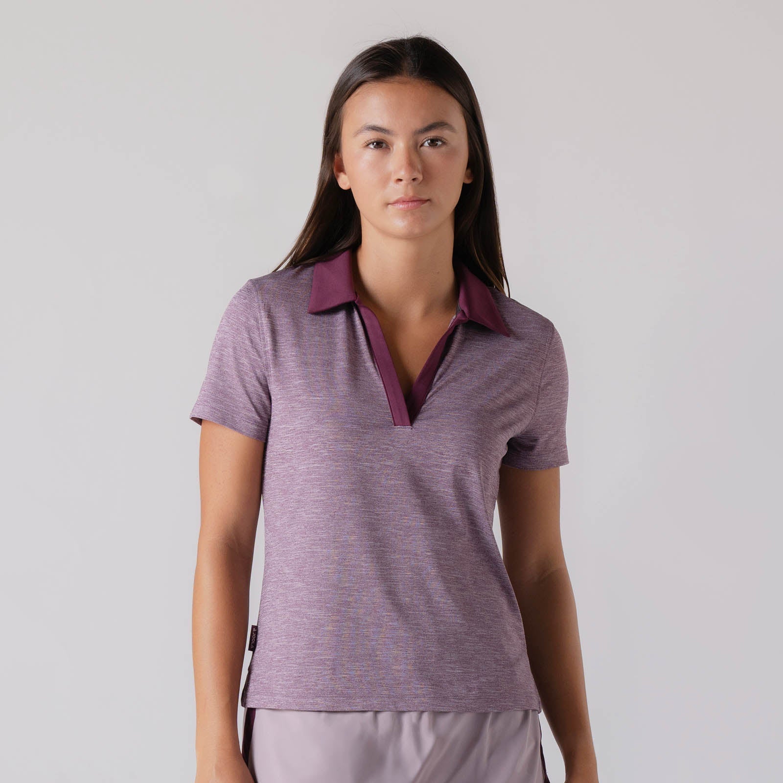 Image showing a female model who is wearing the JOOLA women's club polo, Bordeaux heather.