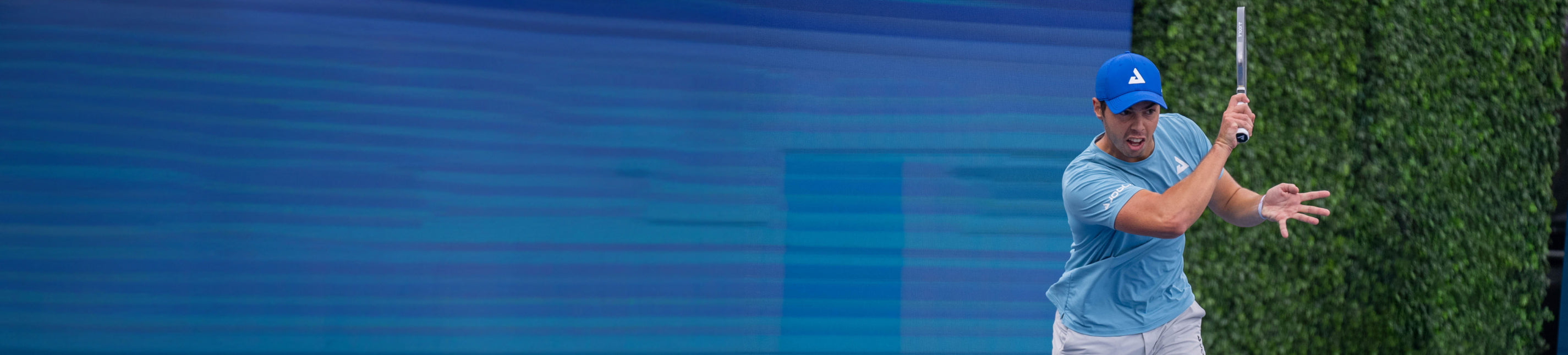 Horizontal banner image of Ben Johns mid swing with his signature JOOLA paddle in hand.