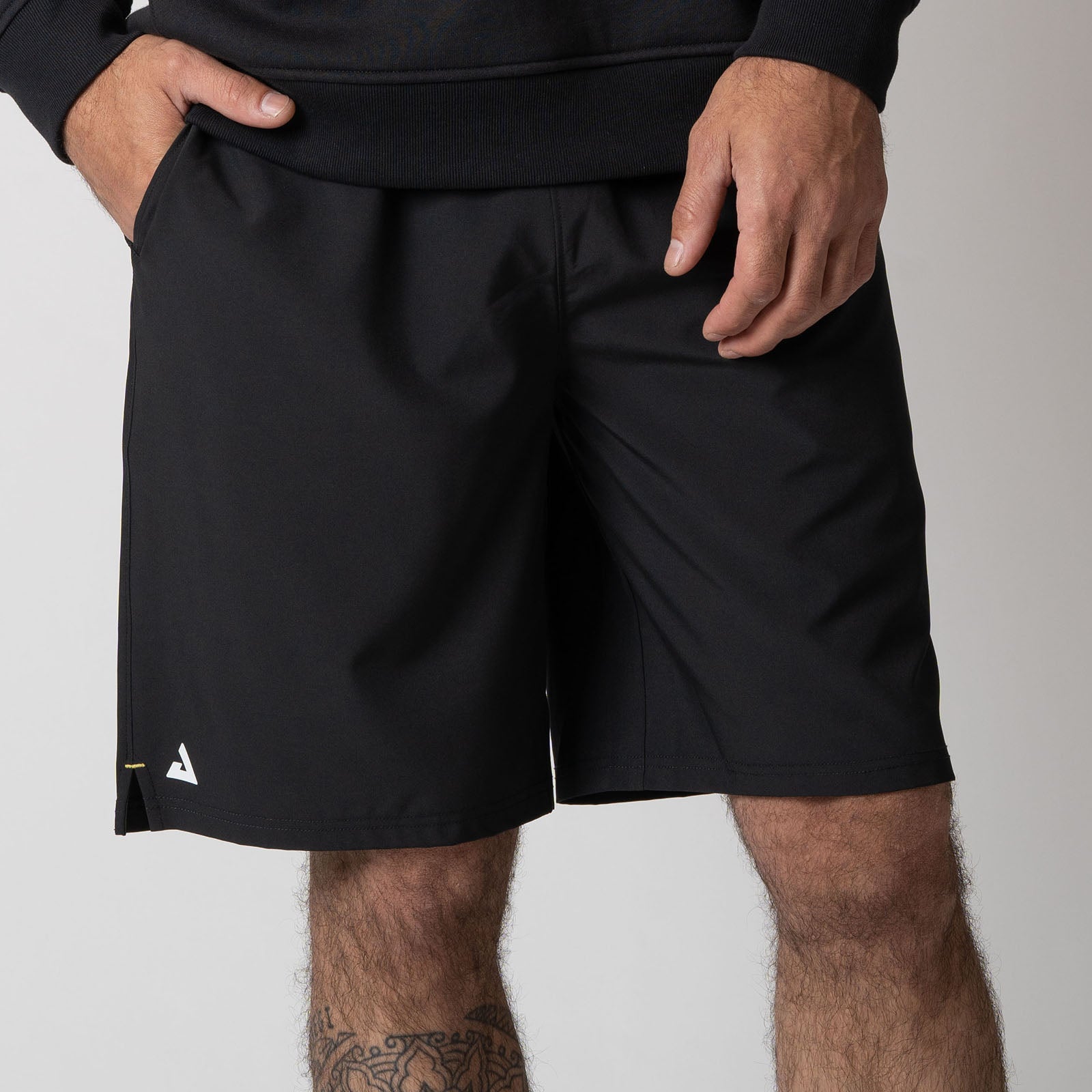 Close up image of a male model wearing a pair of JOOLA Men's Woven Shorts with a Nine-Inch Inseam, Black.