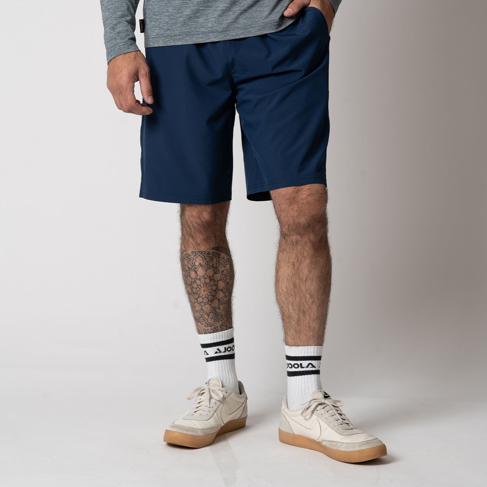Image of a male model wearing a pair of JOOLA Men's Woven Shorts with a Nine-Inch inseam, navy.