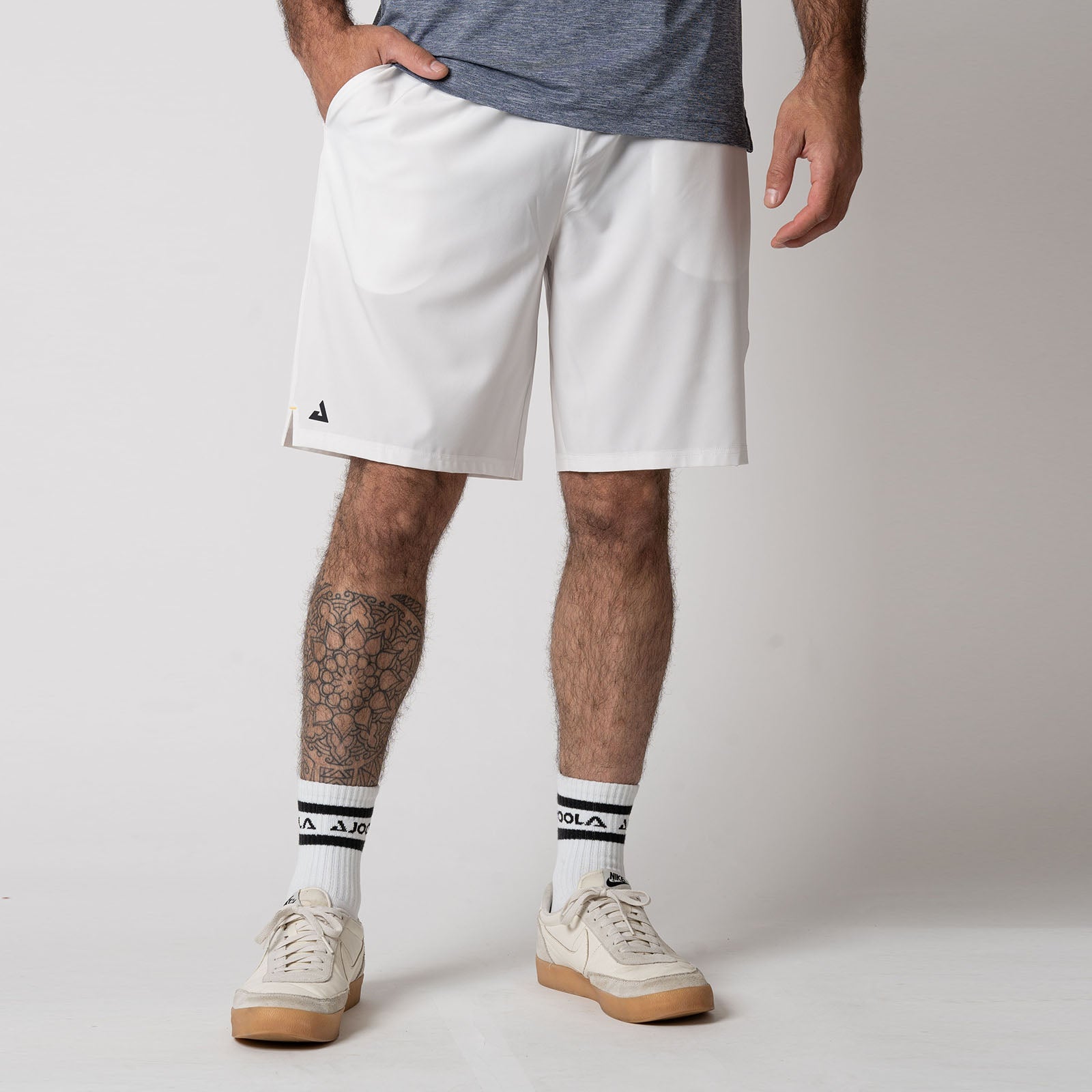 Image showing a male model wearing a pair of JOOLA Men's Woven Shorts with a Nine-inch inseam, white.
